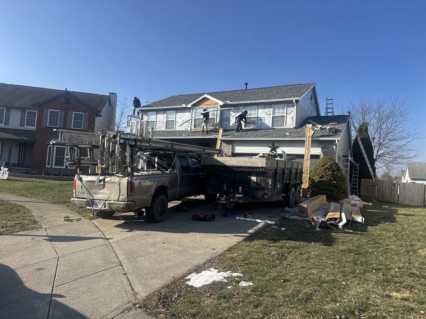 Crew installing new siding and roof on a two-story home