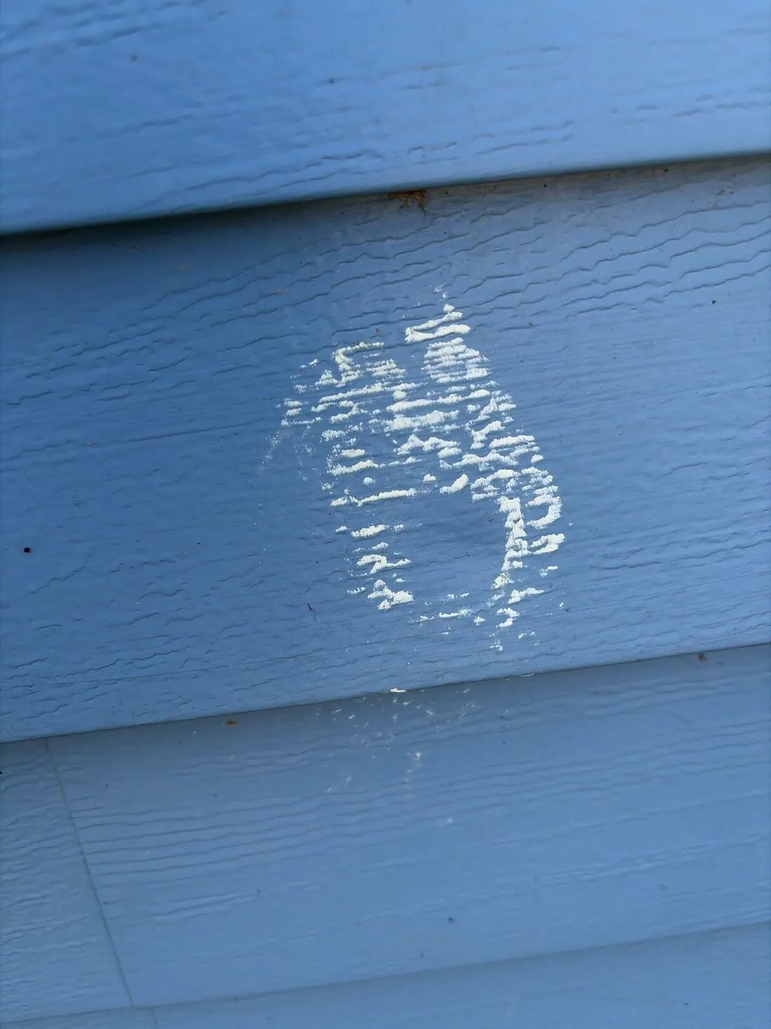Aluminum siding: Hail dent outlined in chalk